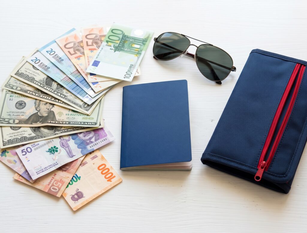 Passport, US dollars and foreign bills ready for a currency exchange near Miami airport